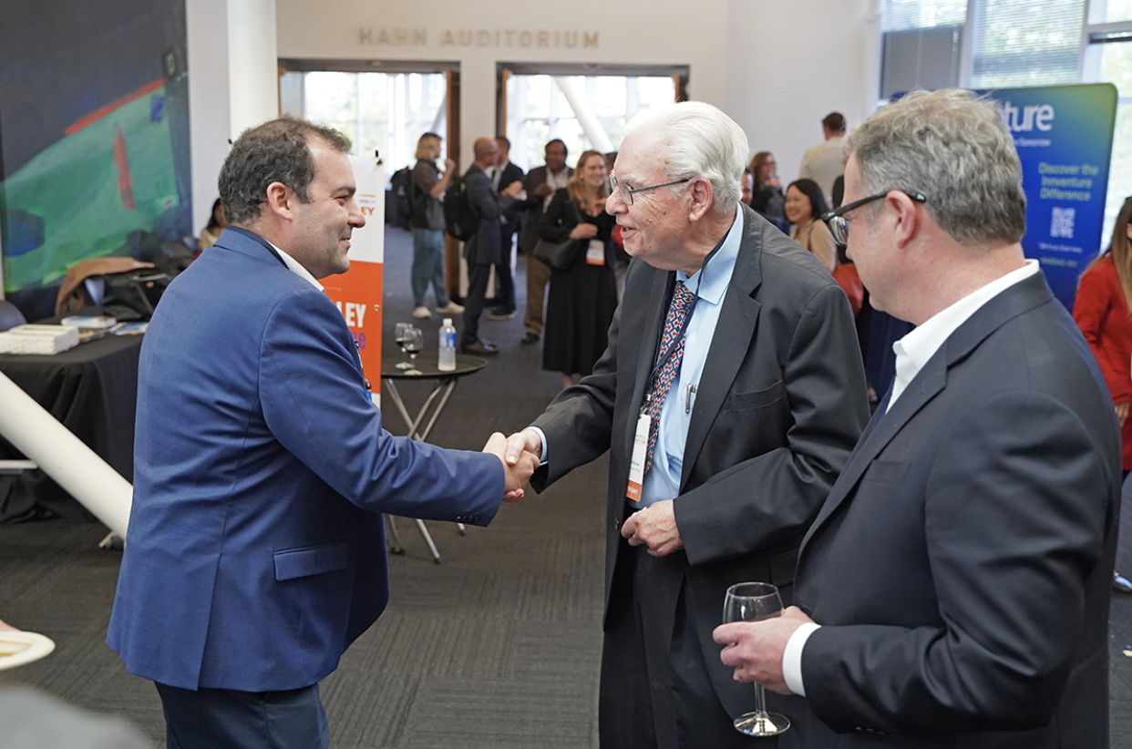 Three male attendees of the Silicon Valley Deal Machine don suits and shake hands. This event, hosted by the Silicon Valley Chapter, brought together over 110 innovation leaders, IP professionals, and business dealmakers at the Computer History Museum in Mountain View, California.
